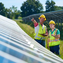 consumers energy workers looking at solar panel
